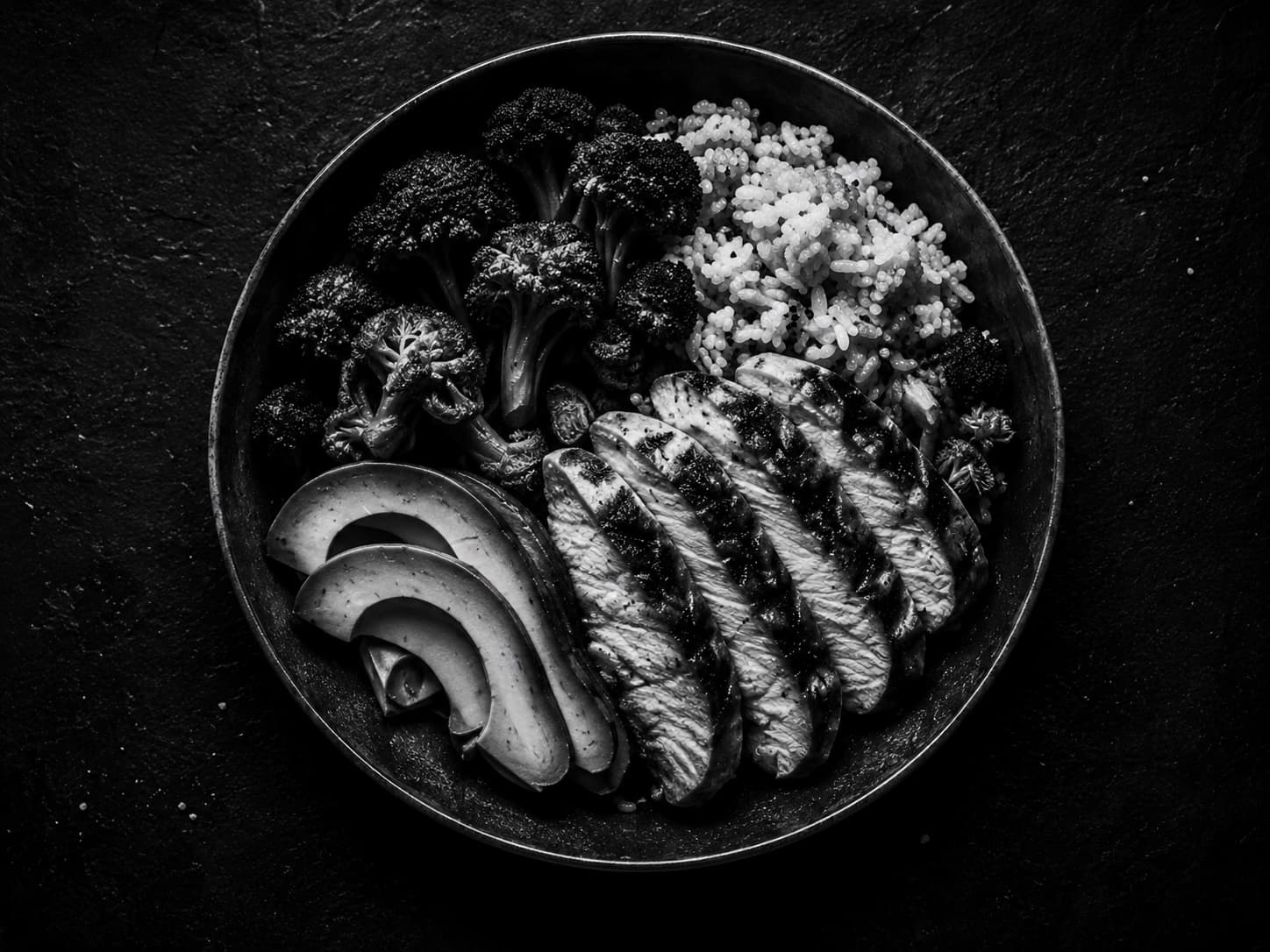 Overhead protein-forward meal bowl on dark slate, in high-contrast black and white